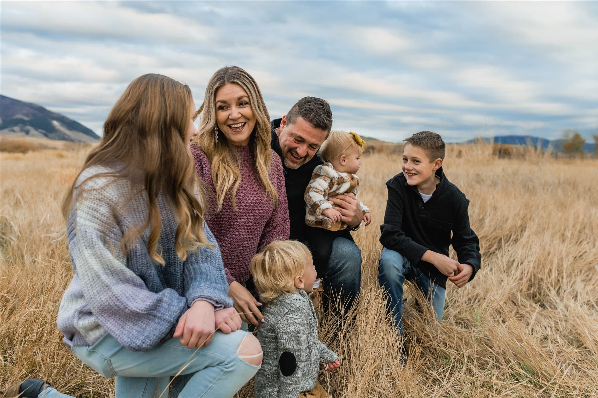 Ken and Shannon Kellum laughing with their children in a Montana field